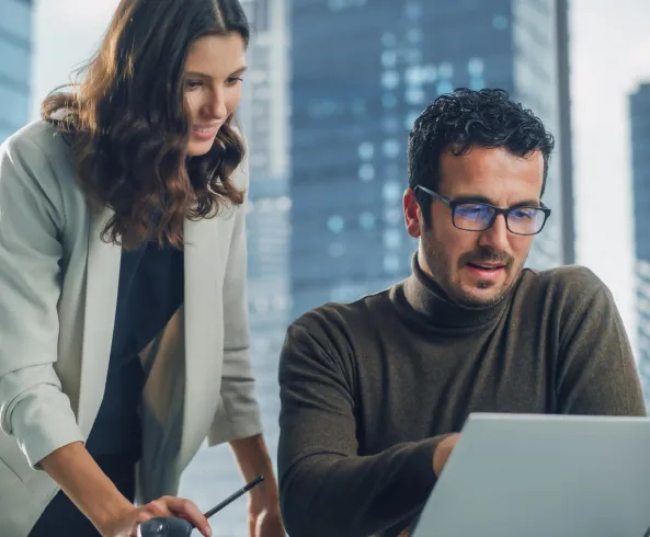 Two people calmly reviewing data in front of a laptop